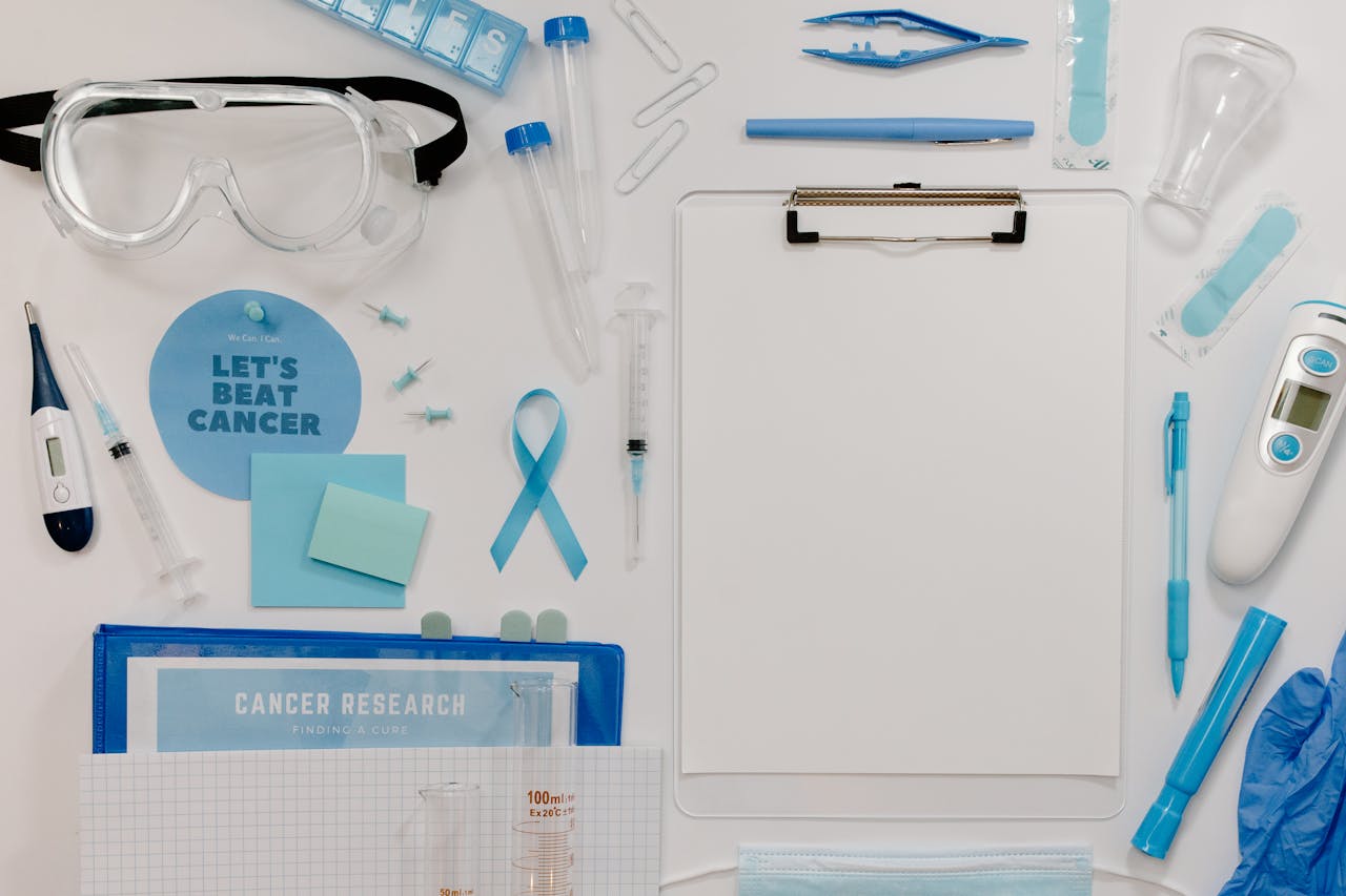 Flat lay of medical tools and cancer awareness symbols promoting cancer research and healthcare.
